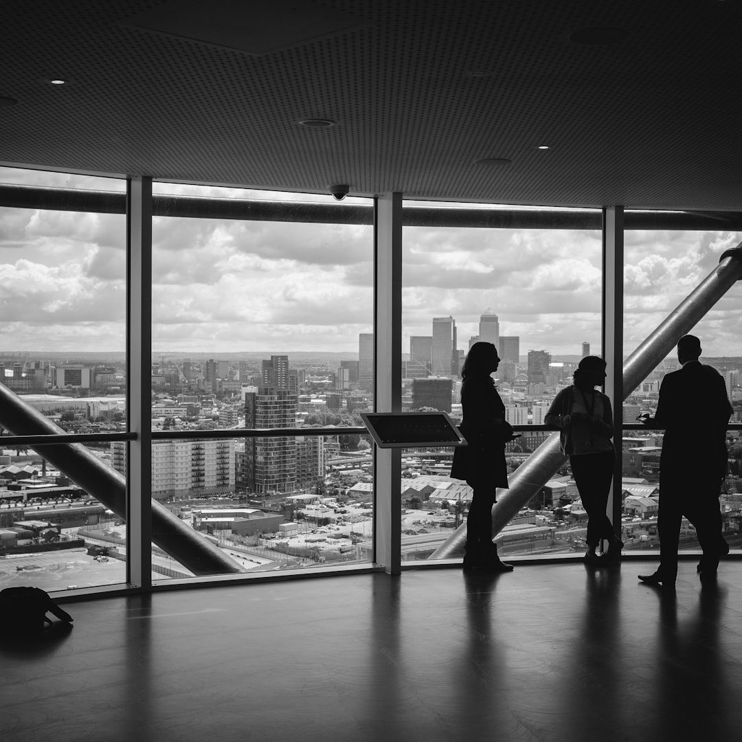 conseils personnalisés Silhouettes de trois personnes devant de grandes fenêtres avec vue sur la ville.